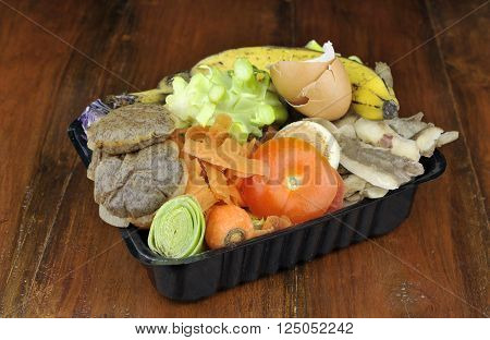 Kitchen food waste vegetables tea bags and fruit collected in re-used packaging for home composting.