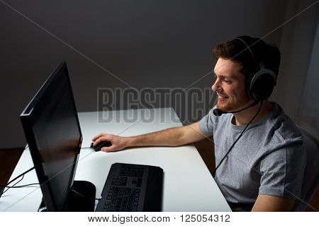 technology, gaming, entertainment, let's play and people concept - happy young man in headset with pc computer playing game at home and streaming playthrough or walkthrough video