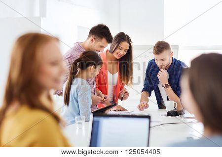 business, startup, education and people concept - happy creative architect team or students with blueprint working at office