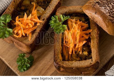 Fresh pea soup in a Bread Bowl, on a wooden board with salt and papper