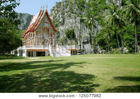 panorama view of nice ethnic Buddhist Thai temple with mountains on the back