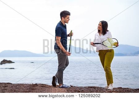 Two young people playing on the seashore speedminton - badminton