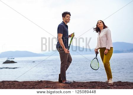 Two young people playing on the seashore speedminton - badminton