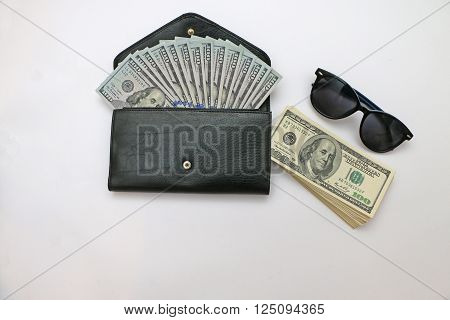 cash in wallets and leather along tinted glasses