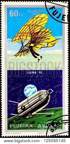 MOSCOW, RUSSIA - APRIL 09, 2016: A stamp printed in Fujeira shows spacecraft Luna 10 and ancient glider (1852), series 
