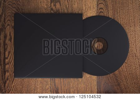 Topview of blank black compact disk with cover on wooden table. Mock up 3D Rendering