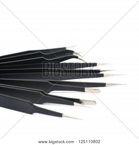 Pile of black metal anti-static tweezers tools isolated over the white background