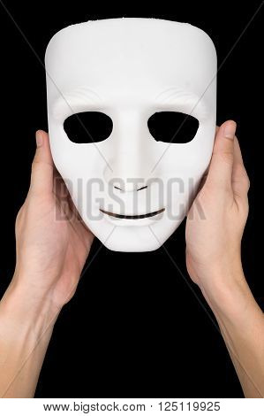 Hand holding a white mask on the black background.