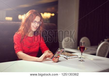 Beautiful girl talking on the phone in a cafe and drink wine,girl in the interior.
