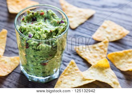Guacamole with tortilla chips on the wooden table
** Note: Shallow depth of field