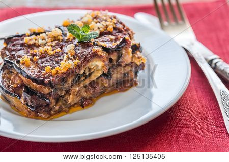Portion of Parmigiana di melanzane on the white plate