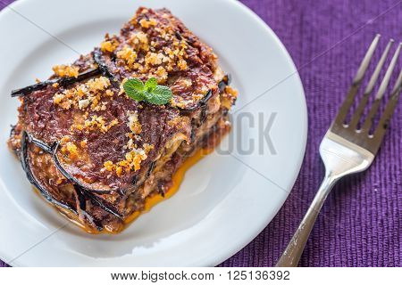 Portion of Parmigiana di melanzane on the white plate