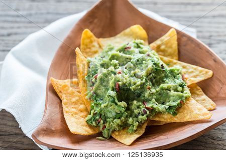 Guacamole with tortilla chips on the rustic bowl
