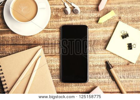 Topview of wooden table with blank phone coffee and office tools. Mock up