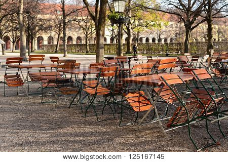 Outdoor Restaurant with wooden desk and chairs in park not open for business yet in the early morning