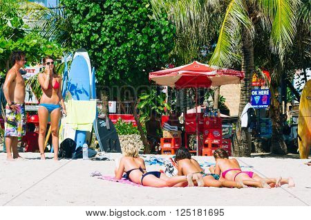 Kuta,Indonesia - JULY 24 : Tourists relax on Kuta Beach on the 24th of july 2009 in BaliIndonesia. Bali is a popular holiday destination especially for young australian and backpackers