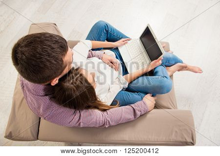 Top View Portrait Of Happy Couple Sitting On Couch With Laptop