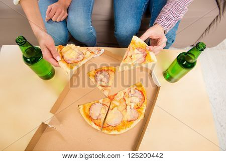 Top View Photo Of Man And Woman Eating Pizza With Beer