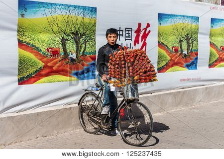 Beijing, China - October 15, 2013: Chinese vendor on his bicycle selling candied fruits (Tanghulu) in Beijing, China.