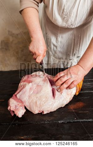 Slicing raw pork meat on piece in farm market.  Butcher slicing raw pork meat in local market. Top view