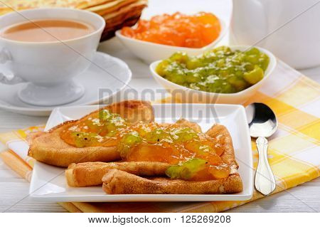 Pancakes with jam and cup of tea.