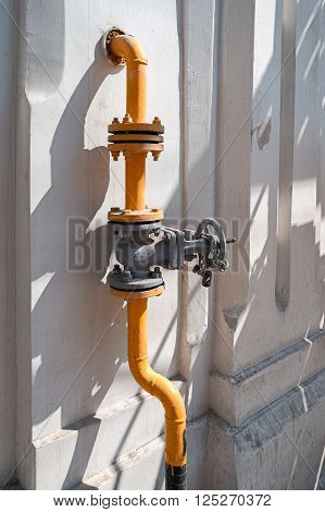 Natural gas valve with steel pipe in bright sunny summer day.