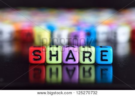 Colorful cube with word Share on wooden table Share on wooden table