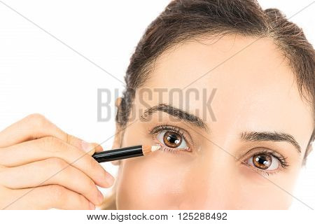 Close up eyes of a woman when using eyeliner. Isolated on white background.