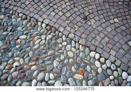 Closeup of cobble and granite pavement texture divided diagonally