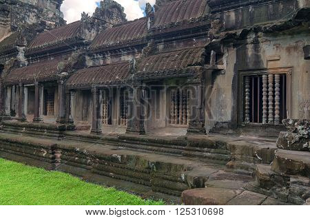 Angkor Wat - a giant Hindu temple complex in Cambodia dedicated to Lord Vishnu. Trees in ruin Ta Prohm part of Khmer temple complex Asia. Siem Reap Cambodia