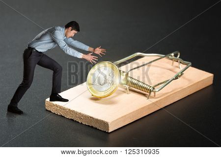 Man trying to pick a gold coin