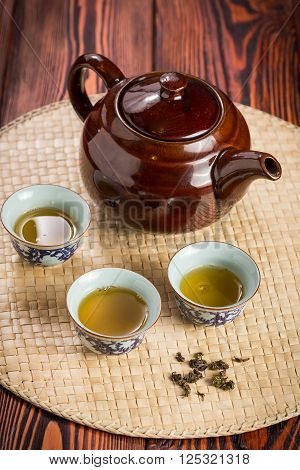 Broun ceramic teapot and cups for the tea ceremony on rustic wooden table