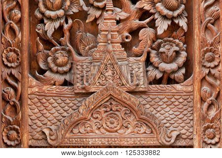 Silhouette of a roof of a Buddhist temple in the tradition of northern Thailand. Carved on a wooden door of Buddhist temple in Chiang Mai Thailand.