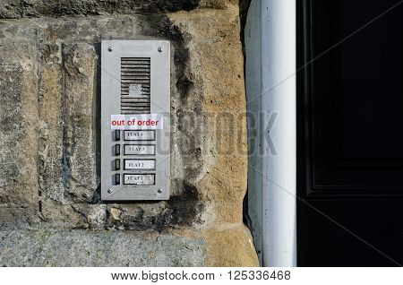 Out of Order sign taped to door bells. Red printed paper sign taped to buzzers on building stated the bells do not work