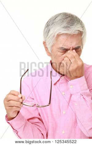 portrait of senior Japanese man suffers from Asthenopia