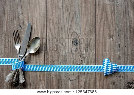 Bavarian cutlery on wooden table with copy space. Oktoberfest beer festival background. Menu for Bavarian specialties