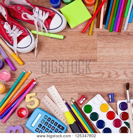 Watercolor paint, brushes and sketch pad and colored pencils on a wooden background. Many different objects for drawing and creativity