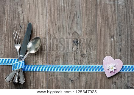Bavarian cutlery on wooden table with copy space. Oktoberfest beer festival background. Menu for Bavarian specialties