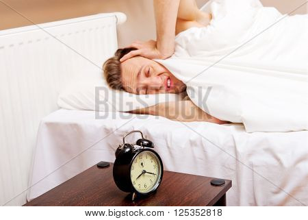 Man trying to sleep, when alarm clock ringing