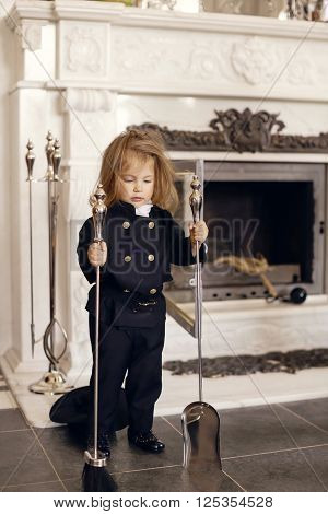 Girl as a chimney sweep against fireplace. Lucky New Year's Eve and New Year.