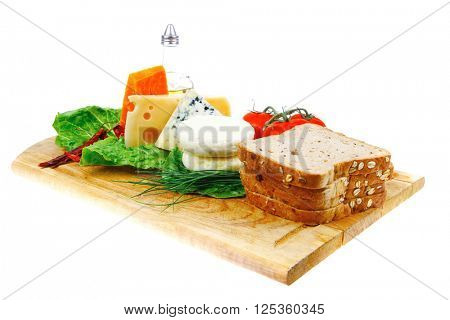 fresh aged french cheeses chops on big cutting board with tomatoes olive oil, rye breadm and green chives isolated over white background