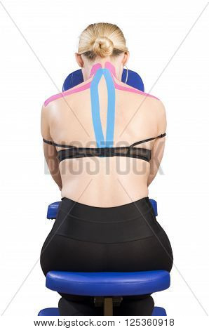 Patient In Massage Chair With Pink And Blue Kinesio Tape.