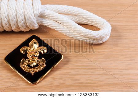 Orderliness White Scout Rope With Vintage Boy Scouts Badge On Wooden Table.