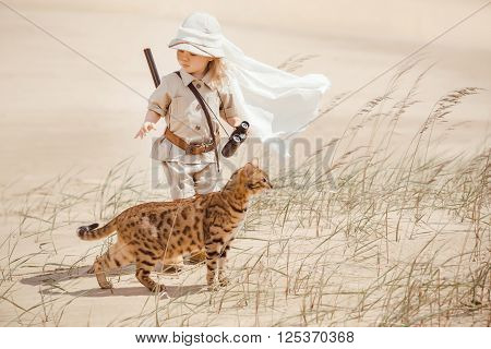 Concept of travel and fascinating adventures. hild in suit of treasures seeker in the desert whit wild cat similar to tiger