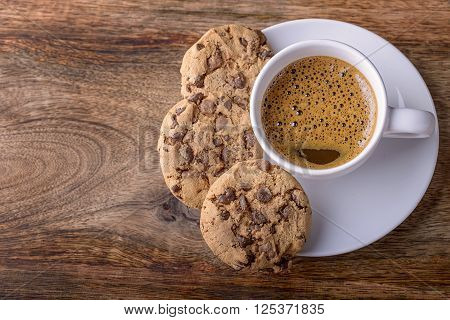 cup of coffee with chocolate cookies on wood