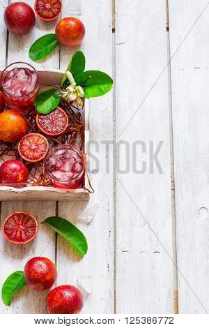 Juicy blood oranges whole and half fresh juice with ice top view space for text.