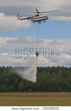 Minsk Belarus-June 21 2014: Staff of Ministry of Emergency Situations Spraying Water over Trees on MI-8 Helicopter During Aviation Sport Event Dedicated to the 80th Anniversary of DOSAAF Foundation in Minsk on June 21 2014 in Minsk Belarus