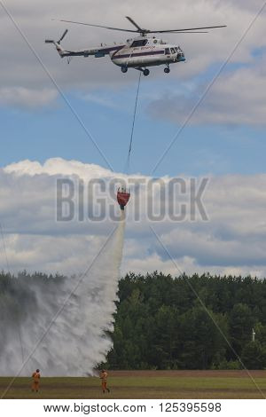 Minsk Belarus-June 21 2014: Staff of Ministry of Emergency Situations Spraying Water over Trees on MI-8 Helicopter During Aviation Sport Event Dedicated to the 80th Anniversary of DOSAAF Foundation in Minsk on June 21 2014 in Minsk Belarus