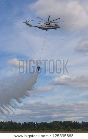 Minsk Belarus-June 21 2014: Staff of Ministry of Emergency Situations Spraying Water over Trees on MI-26 Helicopter During Aviation Sport Event Dedicated to the 80th Anniversary of DOSAAF Foundation in Minsk on June 21 2014 in Minsk Belarus