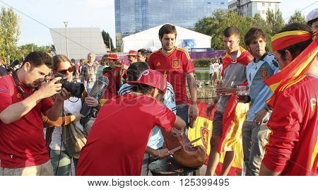 DONETSK UKRAINE - JUNE 27 2012: Unidentified Spanish soccer fans regale jamon before UEFA EURO 2012 match in Donetsk near Donbass Arena